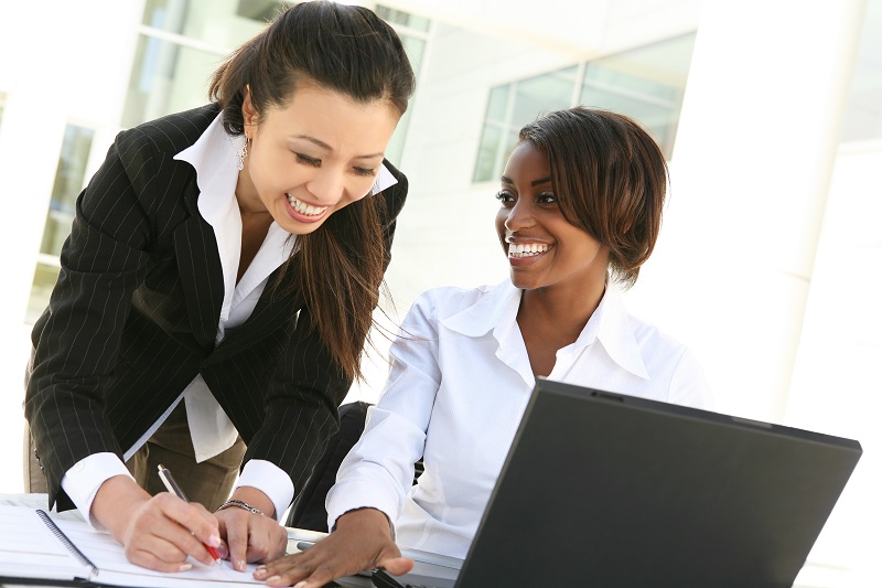 a few women looking at a laptop.