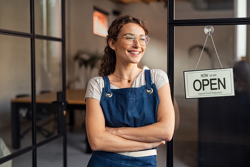 a person standing in front of a door. Containing the words: now we are open support local businesses