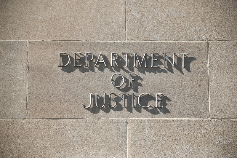 a sign on a wall. Containing the words: department of justice