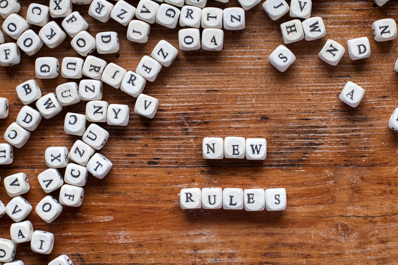 a pile of white cubes with letters on a wooden surface.