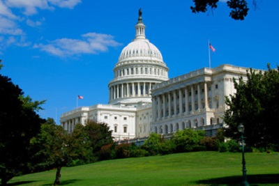 a white building with a dome with United States Capitol in the background.