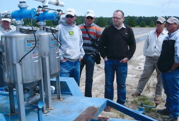 a group of men standing next to a machine.