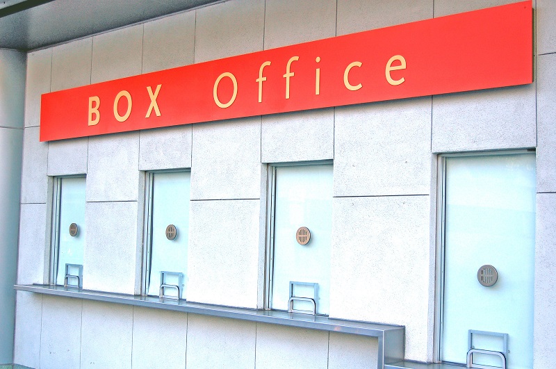 a red sign with gold letters. Containing the words: box office