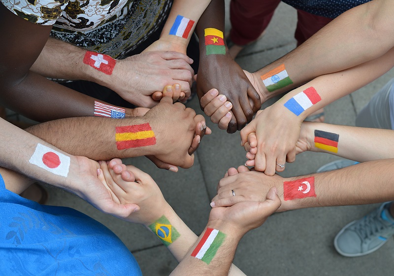 a group of people holding hands with flags on their hands.