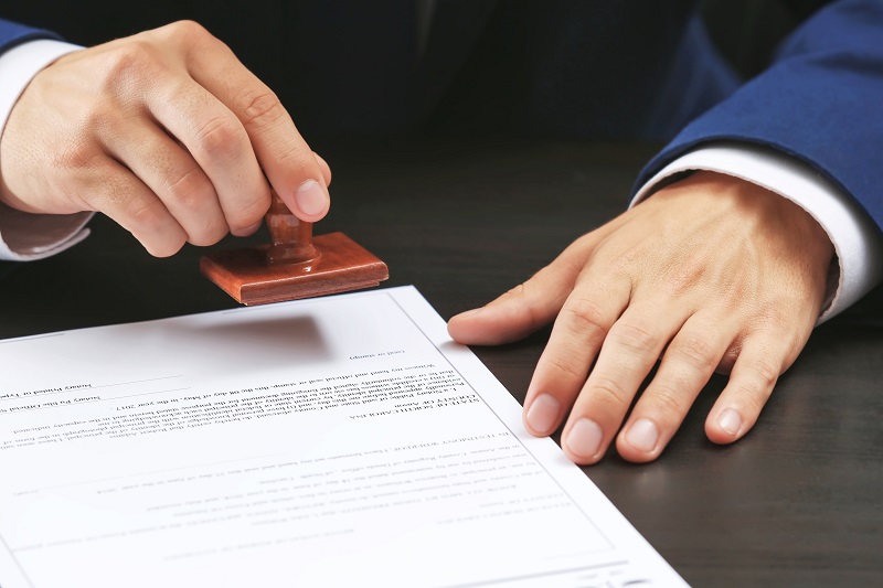 a person stamping a document.