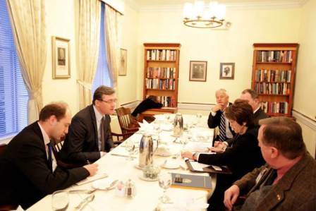 a group of people sitting at a long table.