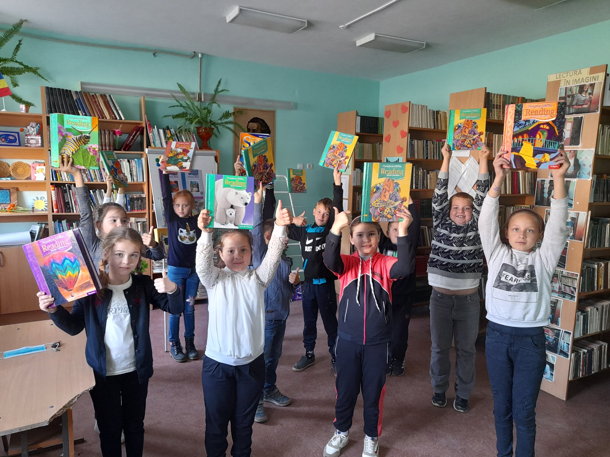 a group of children holding books in a library.