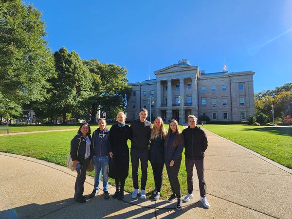 a group of people posing for a photo in front of a building.