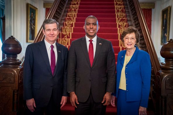 a group of people standing in front of red stairs.