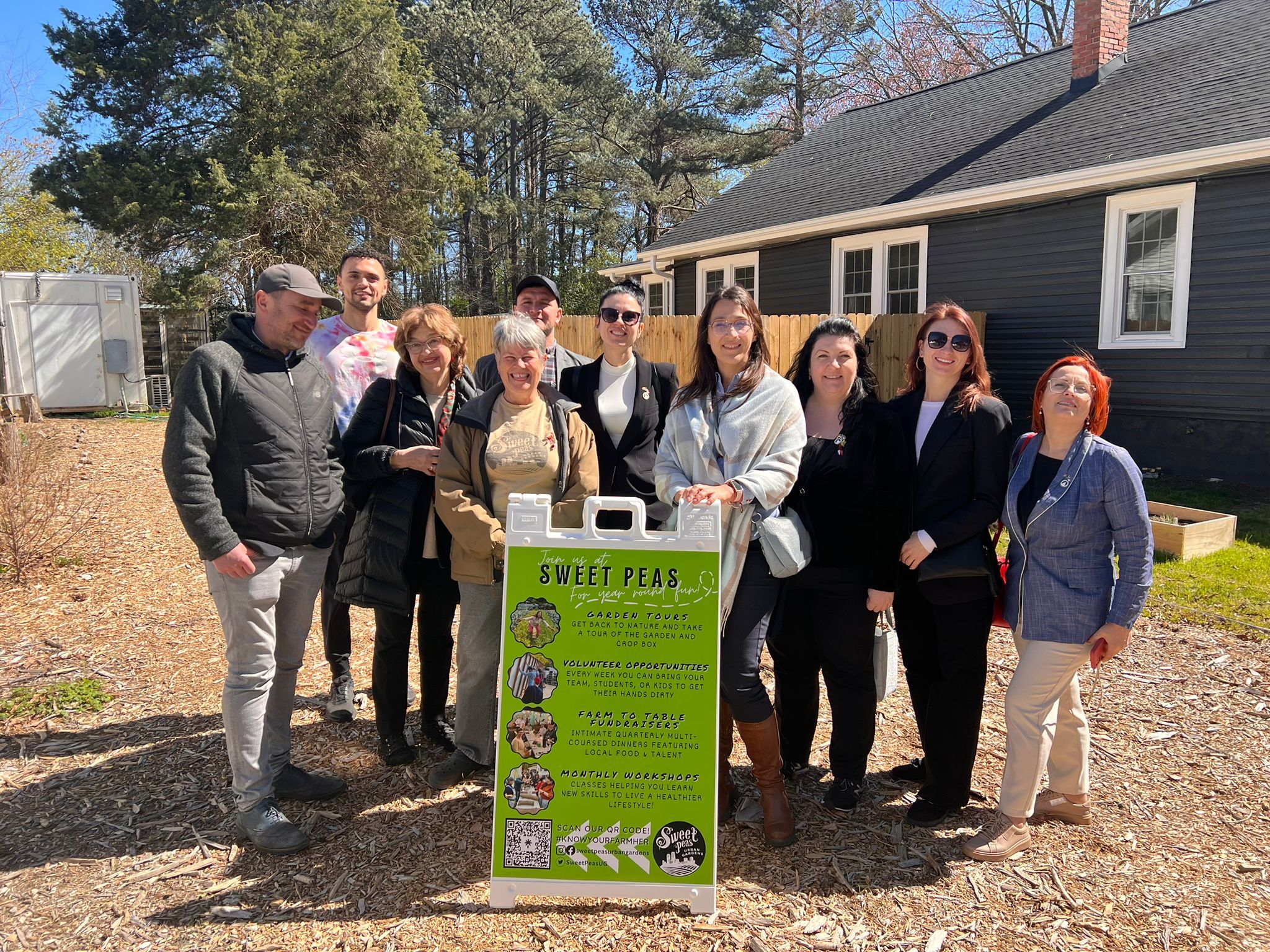 a group of people standing in front of a sign.